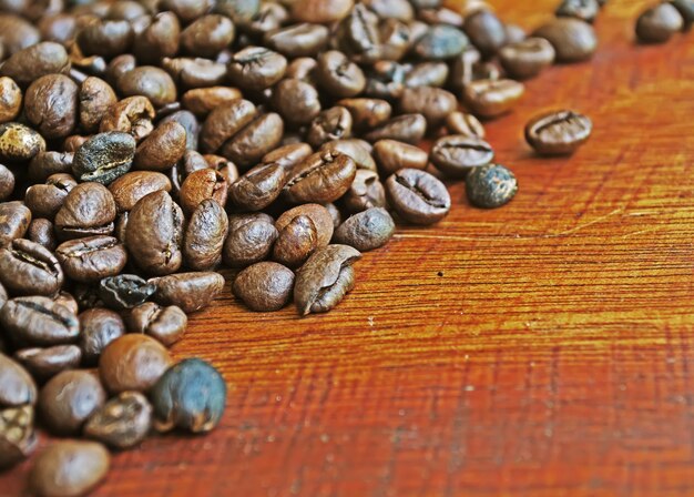 Cerca de granos de café en una mesa de madera