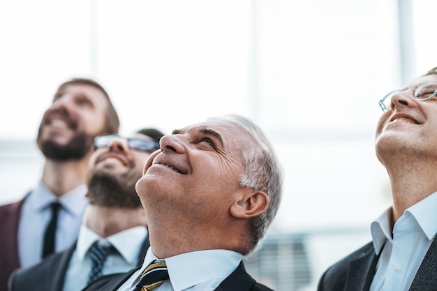 De cerca. grupo de gente de negocios feliz mirando hacia arriba