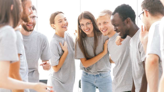 De cerca. grupo de jóvenes felices de pie en una habitación luminosa