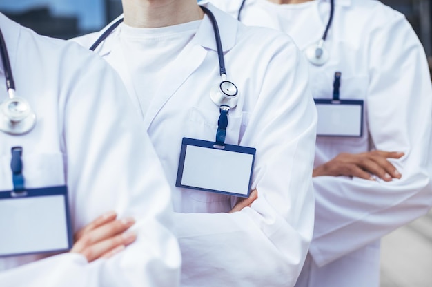 De cerca. grupo de paramédicos con insignias en blanco de pie en una fila. el concepto de protección de la salud.