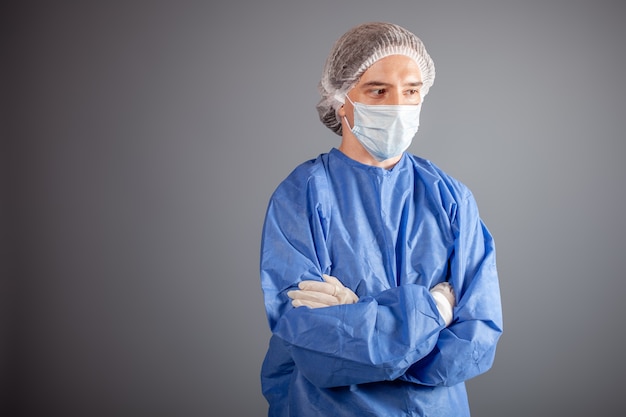 Foto cerca de guapo cirujano vestido con traje protector