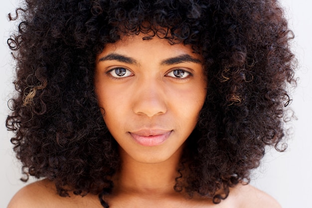 Cerca de la hermosa cara de niña afroamericana con el pelo largo y rizado