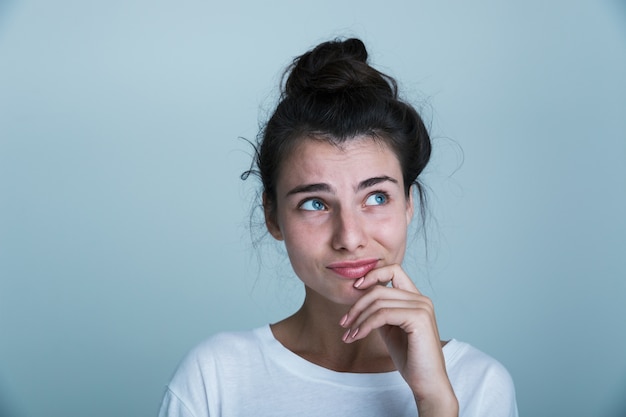 Foto cerca de una hermosa joven casual aislado sobre fondo azul, mirando a otro lado