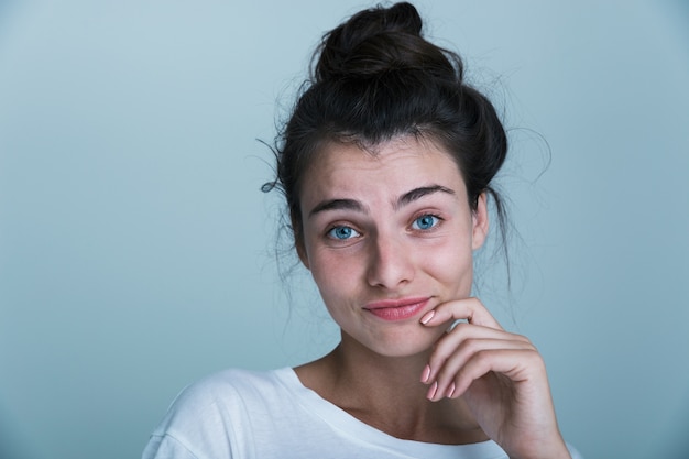 Cerca de una hermosa joven casual aislado sobre fondo azul.