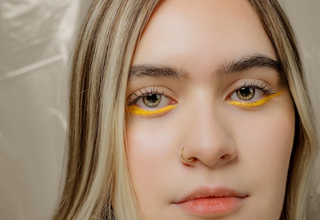 Cerca de hermosa mujer caucásica con delineador de ojos amarillo