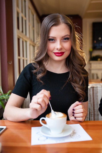 Cerca de hermosa mujer tomando café