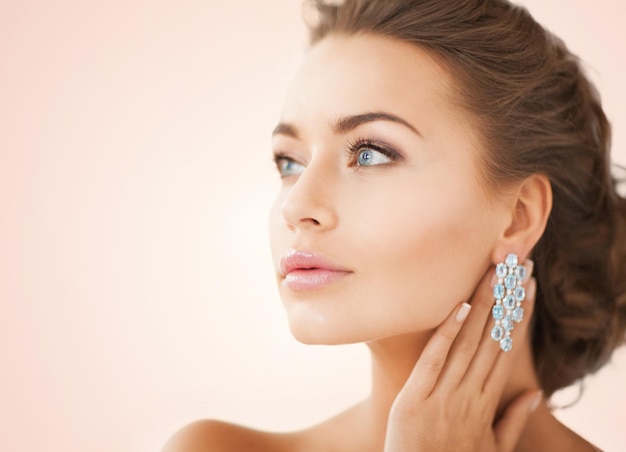 Cerca de hermosa mujer vistiendo aretes de diamantes brillantes