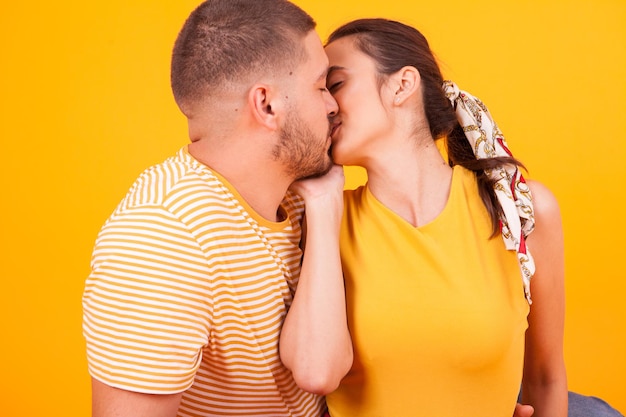 Foto cerca de una hermosa novia besando a su novio en el estudio. pareja romantica.