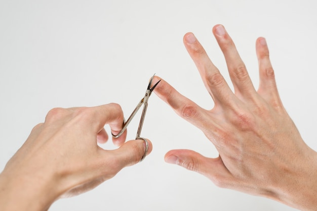 Foto cerca de un hombre cortándose las uñas
