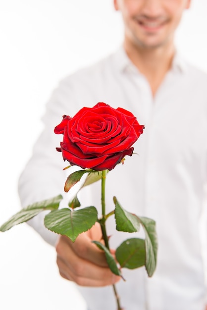 Cerca de un hombre guapo romántico con una rosa roja