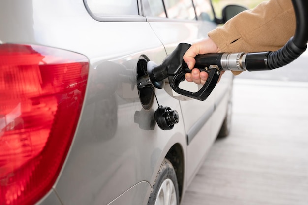 Cerca de un hombre llenando el tanque de combustible de su automóvil con combustible diesel en la gasolinera