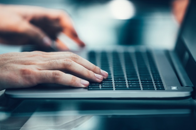 De cerca. hombre moderno escribiendo en un teclado de computadora portátil.