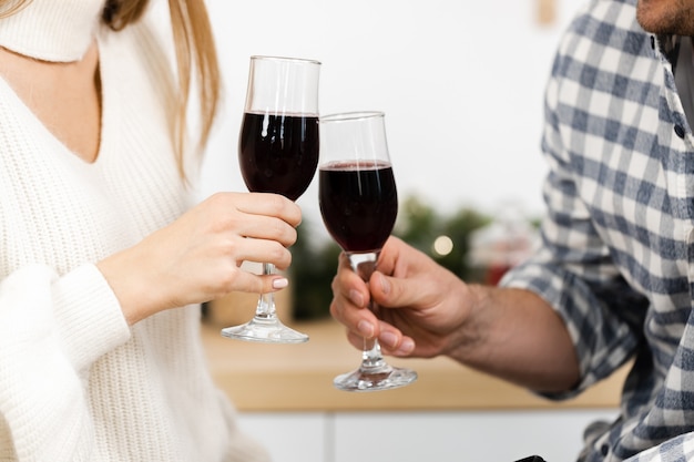 Cerca de un hombre y una mujer bebiendo vino tinto