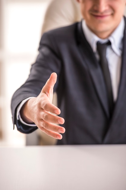 De cerca. Hombre de negocios que da la mano para sacudir las manos.