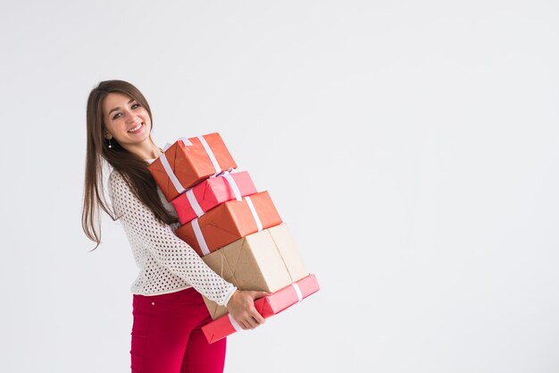 - Cerca del hombre que sostiene una gran cantidad de regalos sobre fondo blanco con espacio de copia.