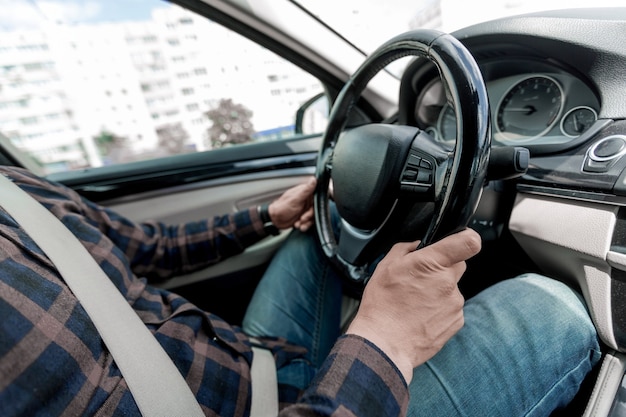 De cerca. un hombre sentado al volante de un coche prestigioso.