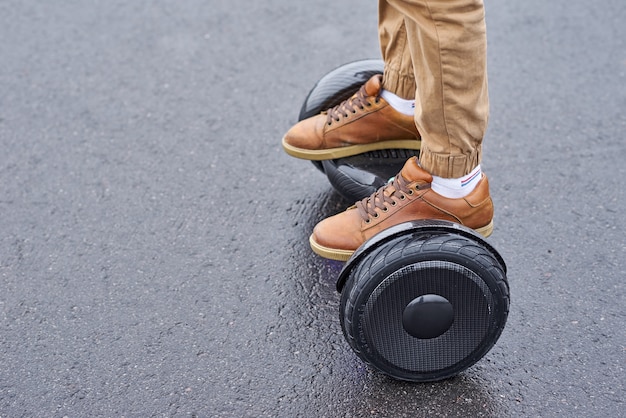 Cerca del hombre usando Hoverboard en la carretera de asfalto