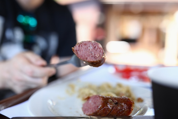 Cerca de la horquilla es un trozo de salchicha frita