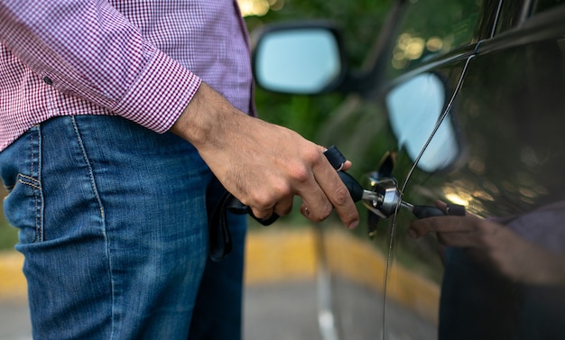 Foto cerca de un joven abriendo la puerta de un coche