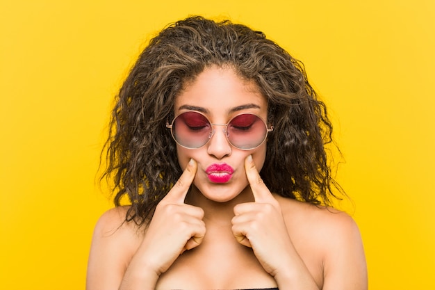 Cerca de una joven afroamericana hermosa y maquillaje mujer con gafas de sol