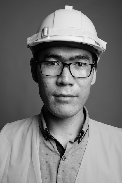 Cerca de joven asiático trabajador de la construcción con anteojos