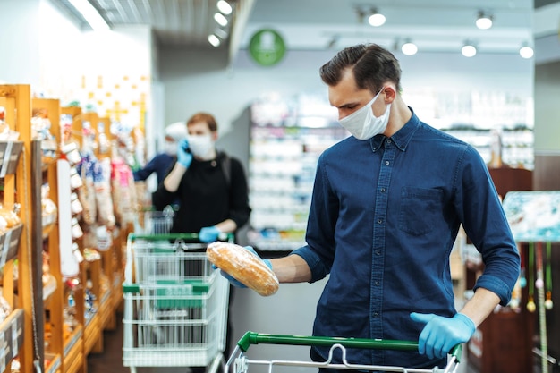 De cerca. joven comprando pan en un supermercado. higiene y cuidado de la salud