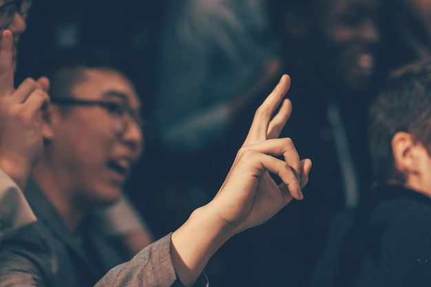 De cerca. joven emprendedor haciendo una pregunta a un orador en un seminario de negocios