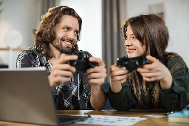 Cerca de una joven familia caucásica sosteniendo joysticks y disfrutando de su tiempo libre jugando juegos nuevos