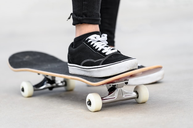 Cerca del joven montando una patineta en el skate park.