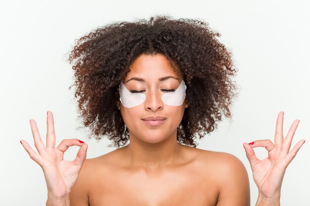 Cerca de una joven mujer afroamericana con un tratamiento para la piel del ojo
