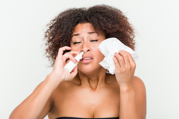 Cerca de una joven mujer afroamericana usando un aerosol nasal