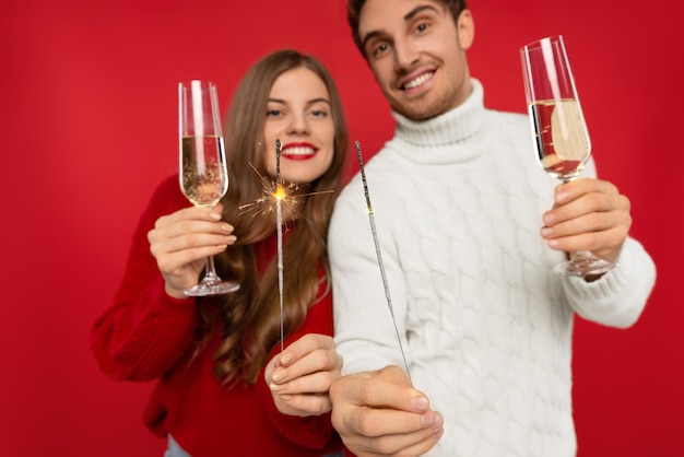 Foto cerca de la joven pareja con copas de champán aislado