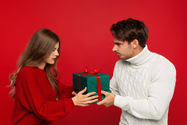 Cerca de la joven pareja con regalo de Navidad aislado