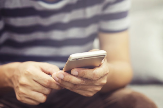 Cerca de joven mediante teléfono móvil inteligente.