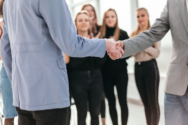 Foto de cerca. jóvenes empresarios dándose la mano. concepto de negocio