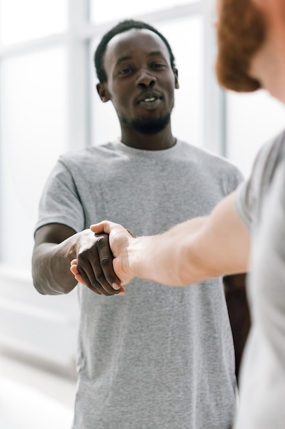 De cerca. jóvenes exitosos dándose la mano. foto con espacio de copia