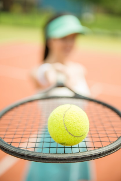 Cerca de un jugador de tenis golpeando la pelota con la raqueta.