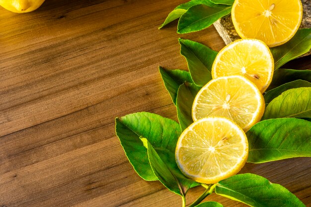 Cerca de limón y hojas verdes sobre fondo de madera