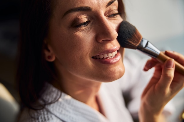 Cerca de linda mujer haciendo maquillaje