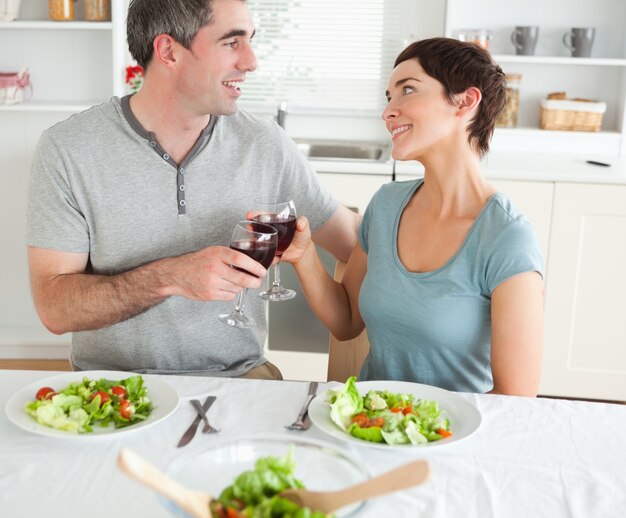 Cerca de una linda pareja brindando con redwine