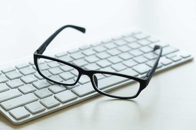 Foto cerca de lugar de trabajo de lugar de trabajo de negocios de computadora y gafas en la oficina