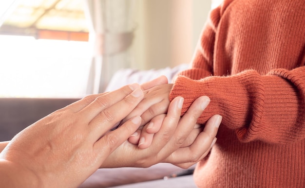 Foto cerca de la madre sosteniendo la mano del bebé en casa para alentar y esperar el concepto de familia feliz