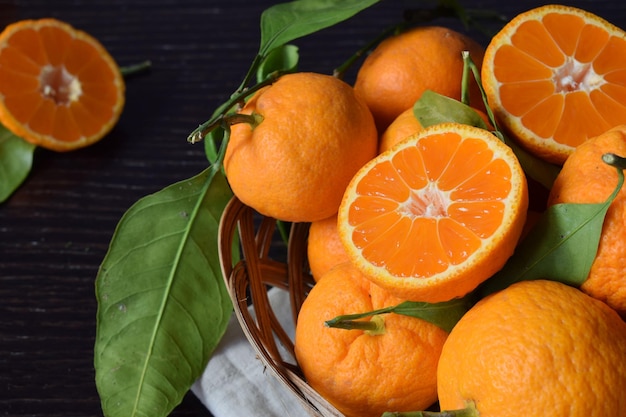 Foto cerca de mandarinas frescas y sabrosas con hojas.