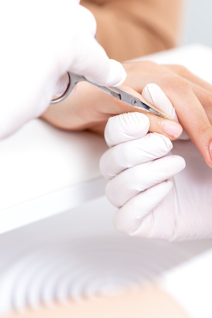 Cerca de manicurista con tijeras de manicura