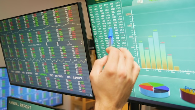 Cerca de la mano del comerciante del mercado de valores en monitores con gráficos financieros. Accidente económico.