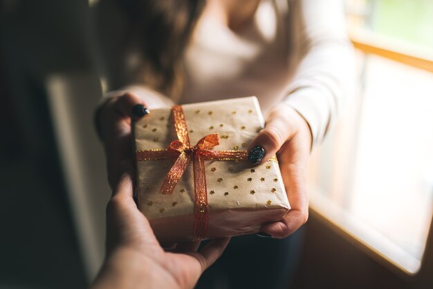 Cerca de una mano dando un regalo a su pareja