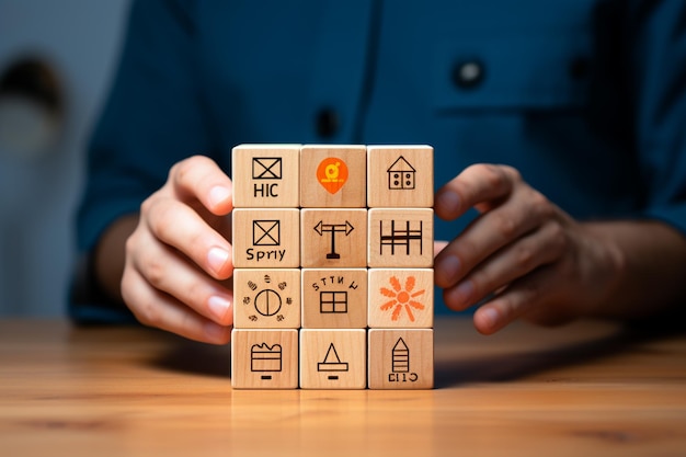 Foto cerca de la mano de la empresaria sosteniendo un cubo de madera con iconos de construcción