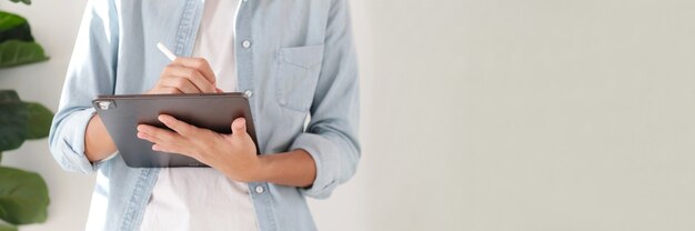 Cerca de la mano del hombre estudiante escribiendo en tableta digital con espacio de copia