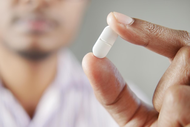 Cerca de la mano del hombre sosteniendo pastillas con espacio de copia