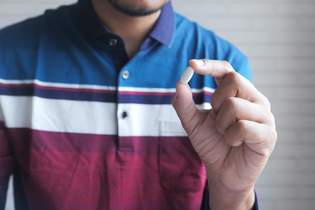 Foto cerca de la mano del hombre sosteniendo pastillas con espacio de copia.